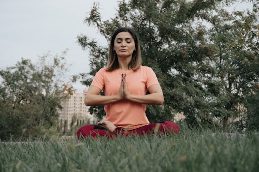 Woman practicing yoga and meditation in park. Enhancing mindfulness and relaxation outdoors.