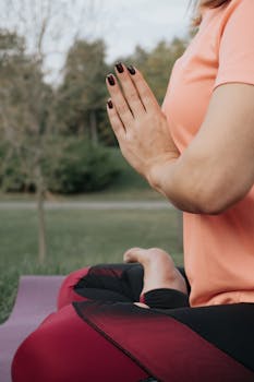 A woman practices yoga meditation outdoors, enhancing mindfulness and relaxation.