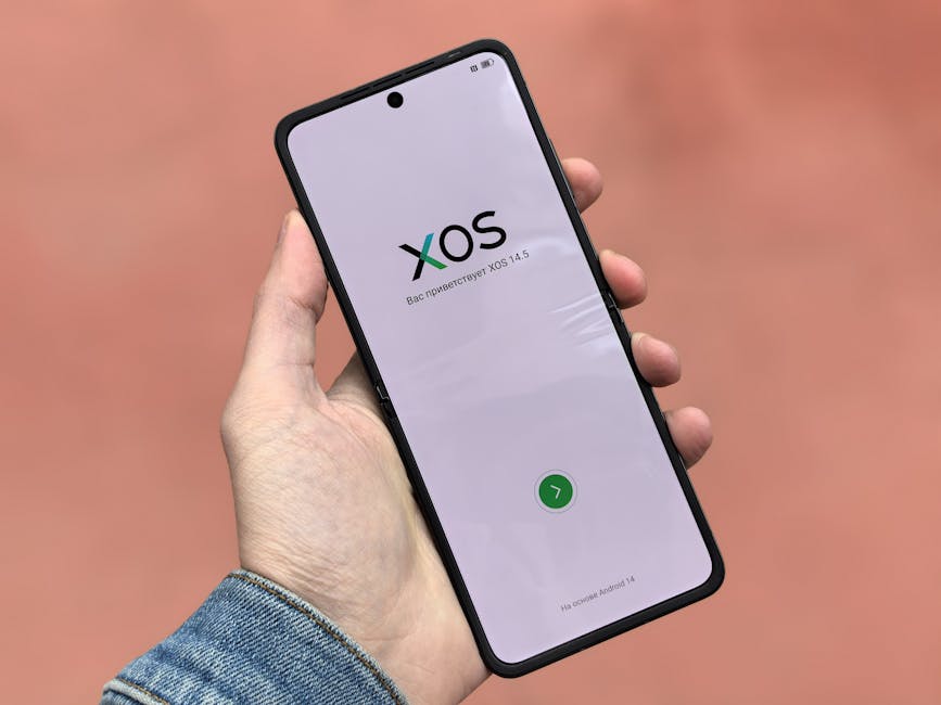 Close-up de um smartphone exibindo a interface do sistema operacional XOS 14.5 em uma mão.