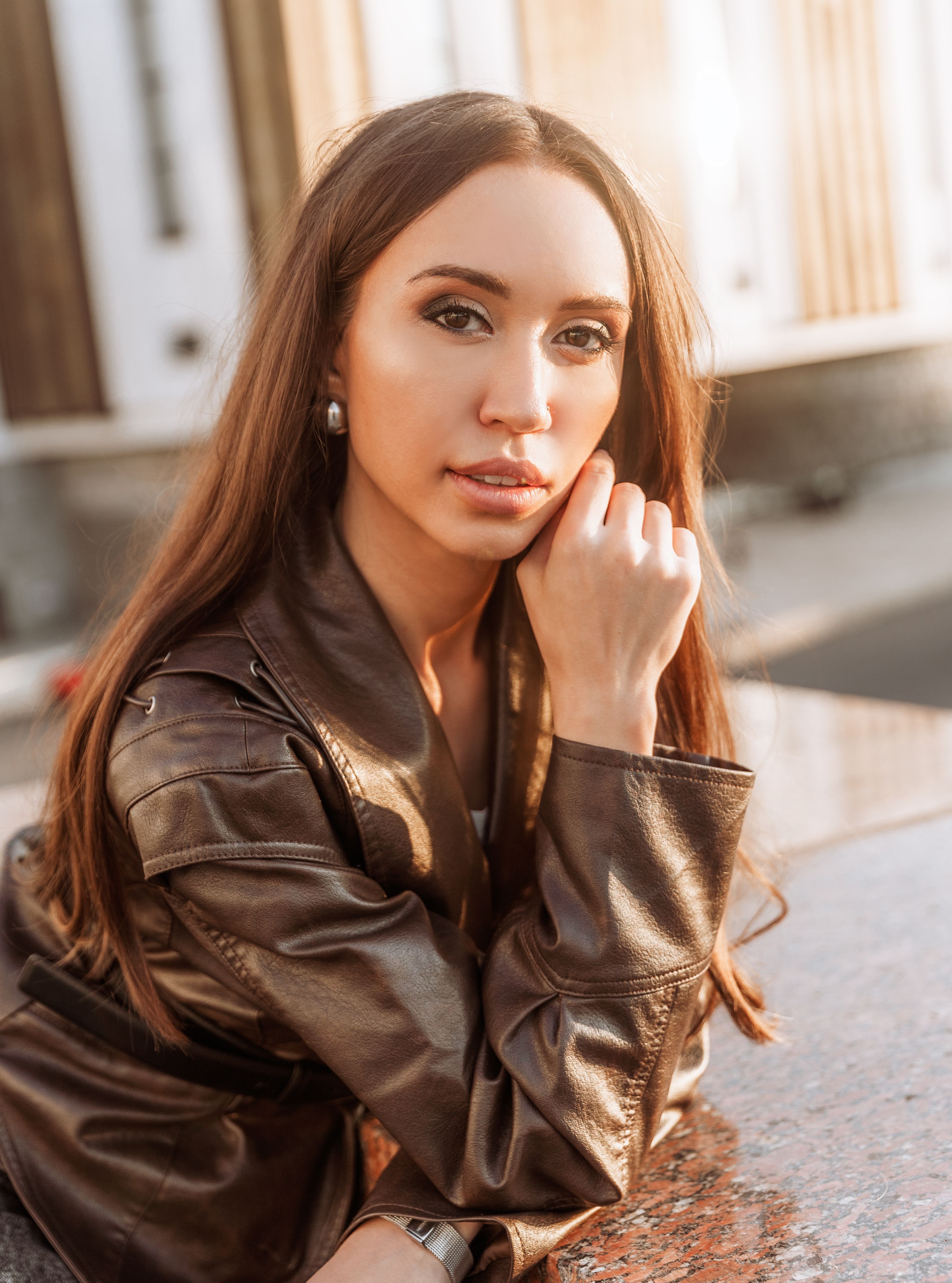 Woman in cognac brown leather jacket with cream trousers