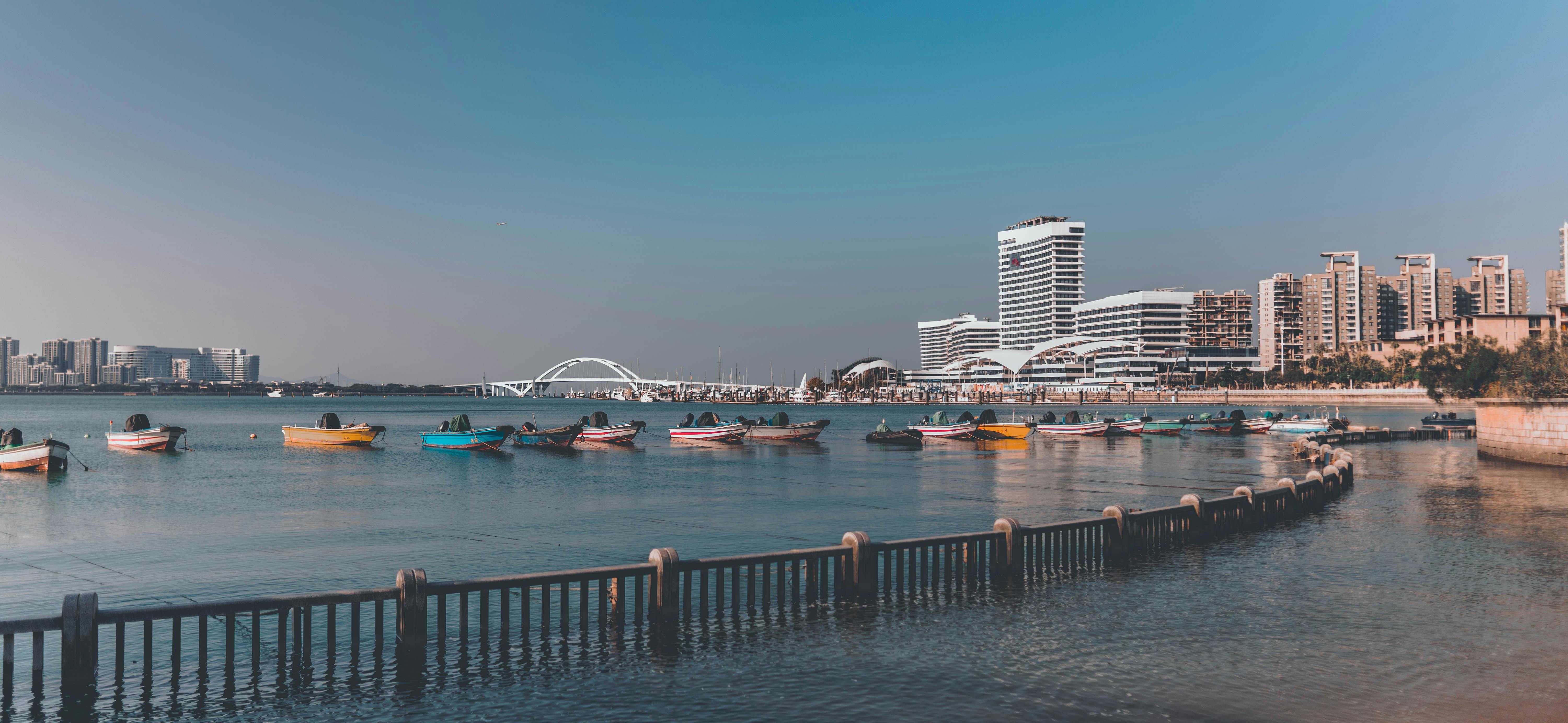 港口停靠着五颜六色的船只，展现出现代海滨城市的全景