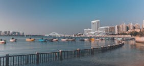 港口停靠着五颜六色的船只，展现出现代海滨城市的全景