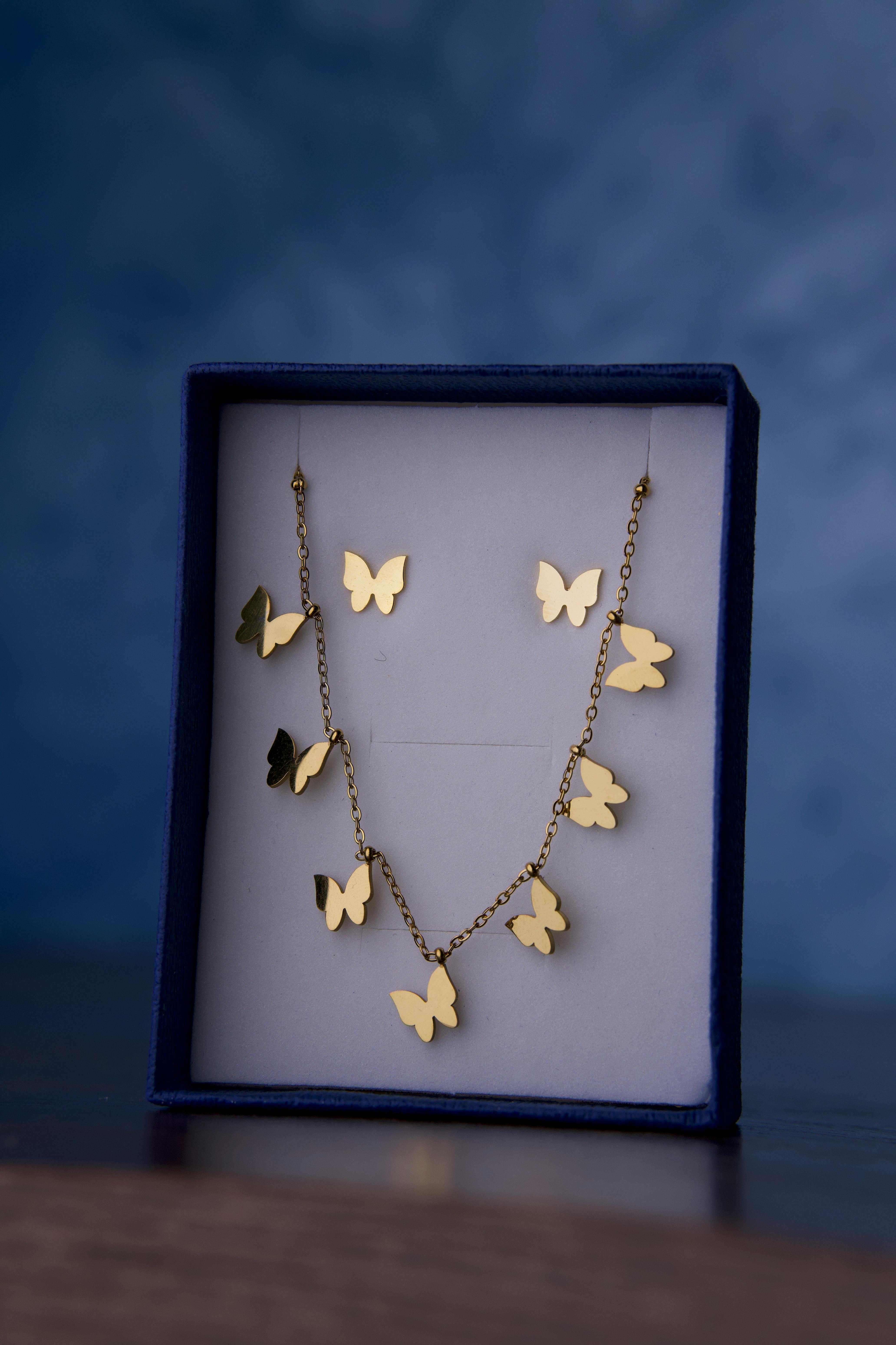 Gold butterfly necklace elegantly presented in a velvet box, perfect for gifting or collection.