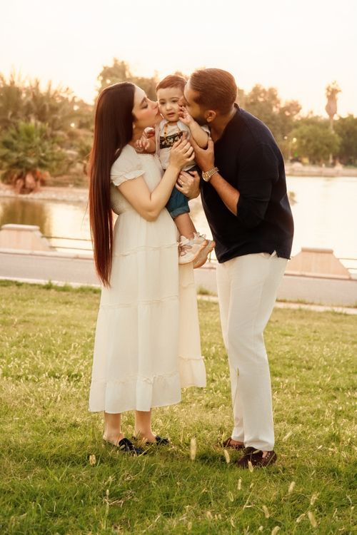 Free A loving family moment in a sunny park setting by the lake. Stock Photo