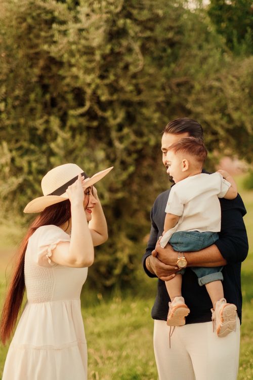 Free Young family spending quality time outdoors on a sunny day, embracing joy and connection. Stock Photo
