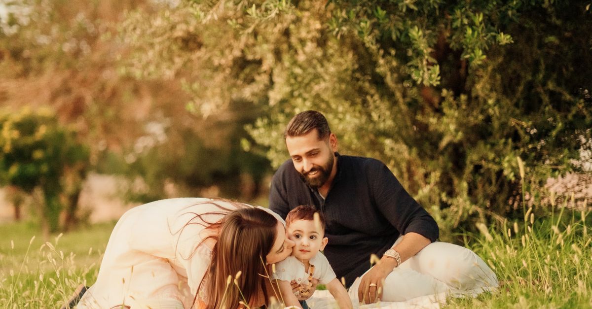 Une famille joyeuse avec des parents et un bébé profitant d'une journée ensoleillée en plein air lors d'un pique-nique.