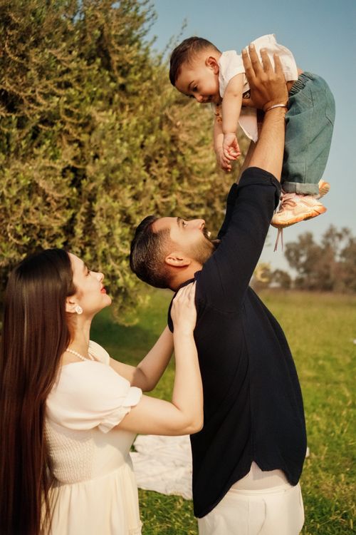 Free Joyful moments of a family playing together in a sunny park, highlighting love and togetherness. Stock Photo