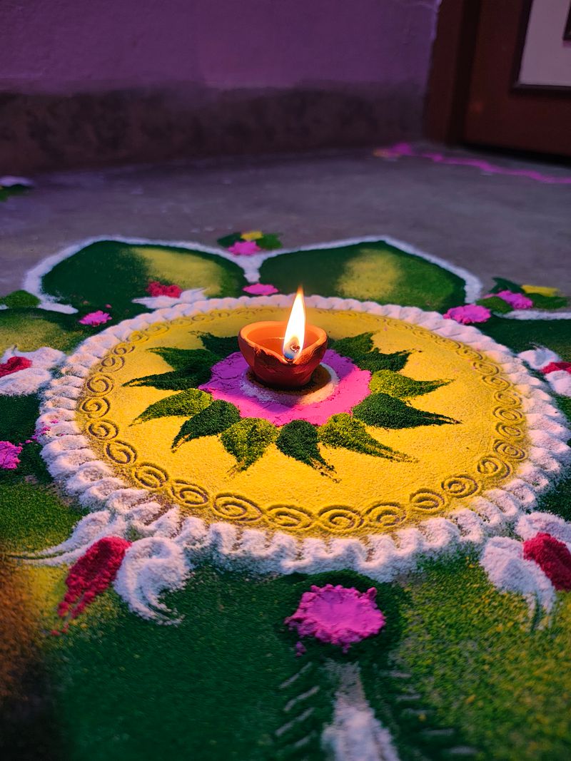 Vibrant rangoli with lit diya for Navratri festival