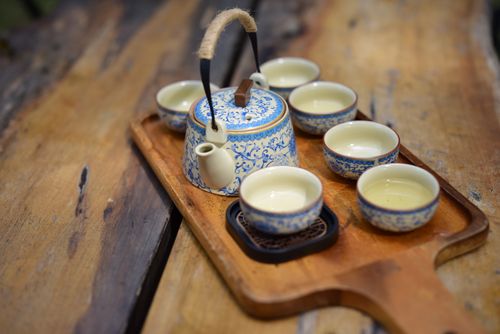Free Blue patterned porcelain teapot set with six cups on a rustic wooden tray. Stock Photo