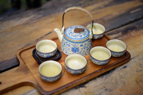 Free Vintage blue ceramic teapot and cups set arranged neatly on a rustic wooden tray, perfect for tea lovers. Stock Photo