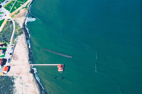 Aerial View of Body of Brown Wooden House Surrounded by Body of Water