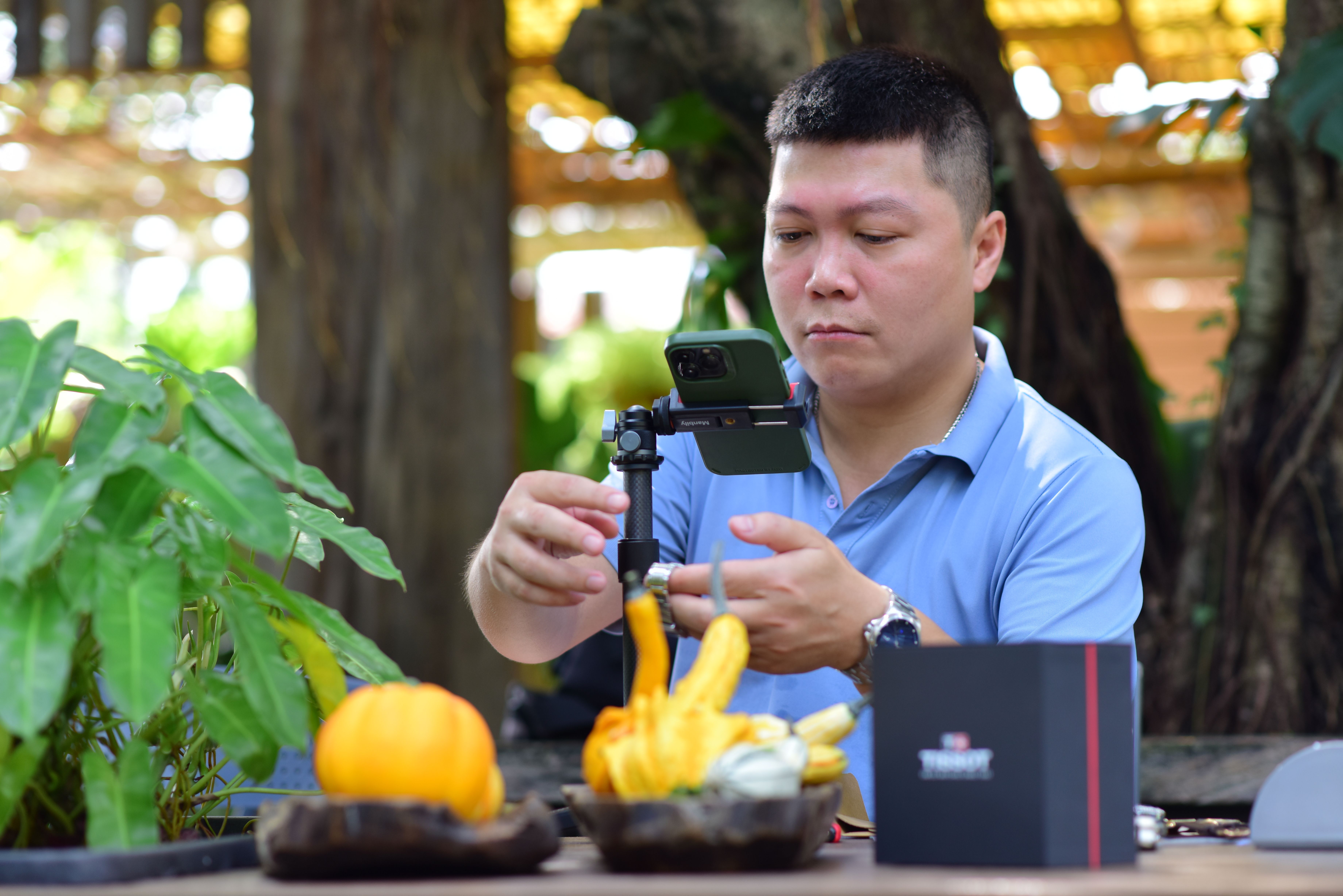 Man Setting Up Smartphone for Tabletop Photography · Free Stock Photo