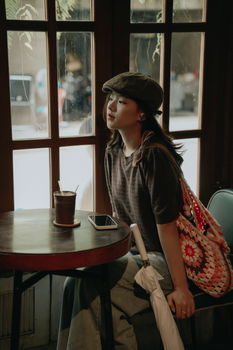 Portrait of a woman sitting in a cafe, enjoying a drink by the window.