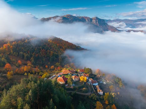 Stunning aerial shot of the Rodopi Mountains showcasing vibrant fall foliage and misty valleys.