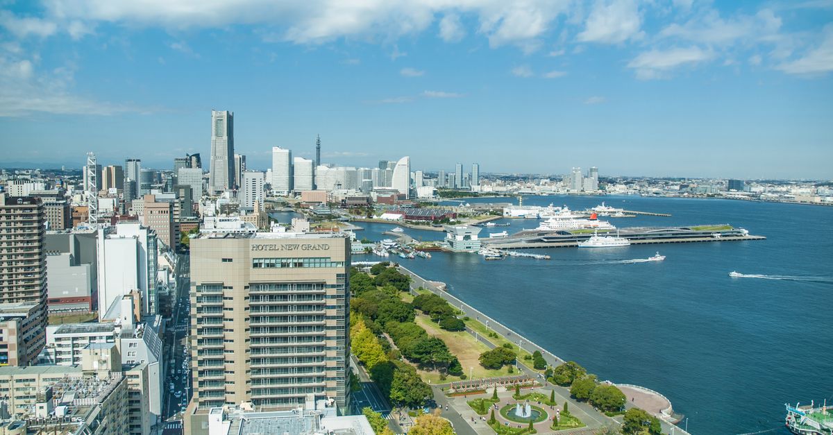 Stunning aerial view of Yokohama skyline with iconic landmarks and harbor on a sunny day.