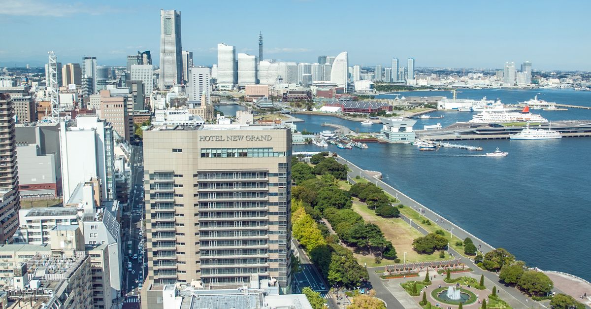 Scenic aerial view of Yokohama city skyline with harbor, skyscrapers, and green park in Japan.