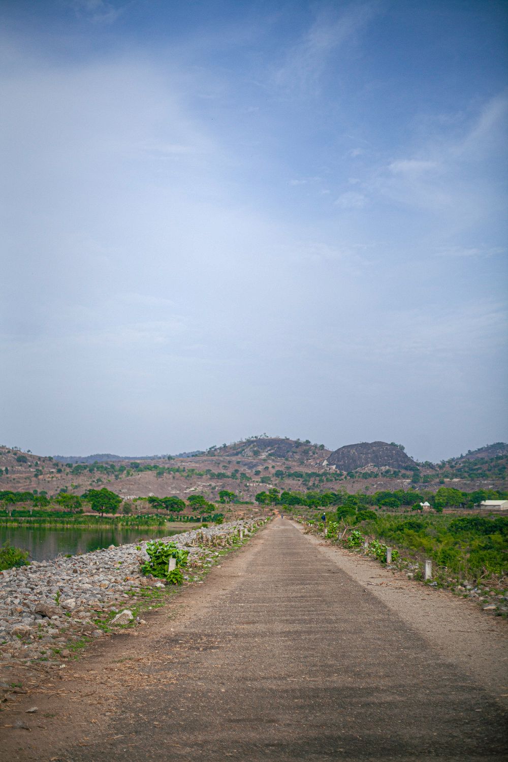 Scenic Rural Road Leading to Distant Hills · Free Stock Photo