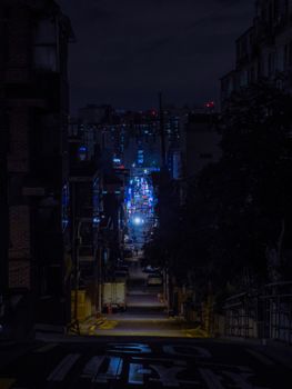 Moody Seoul street scene at night with vibrant neon lights.