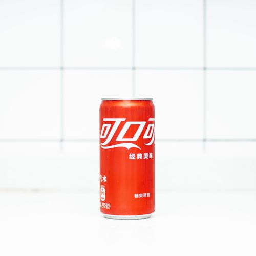 Free Minimalist image of a red soda can against a white tiled background, offering a clean and modern aesthetic. Stock Photo
