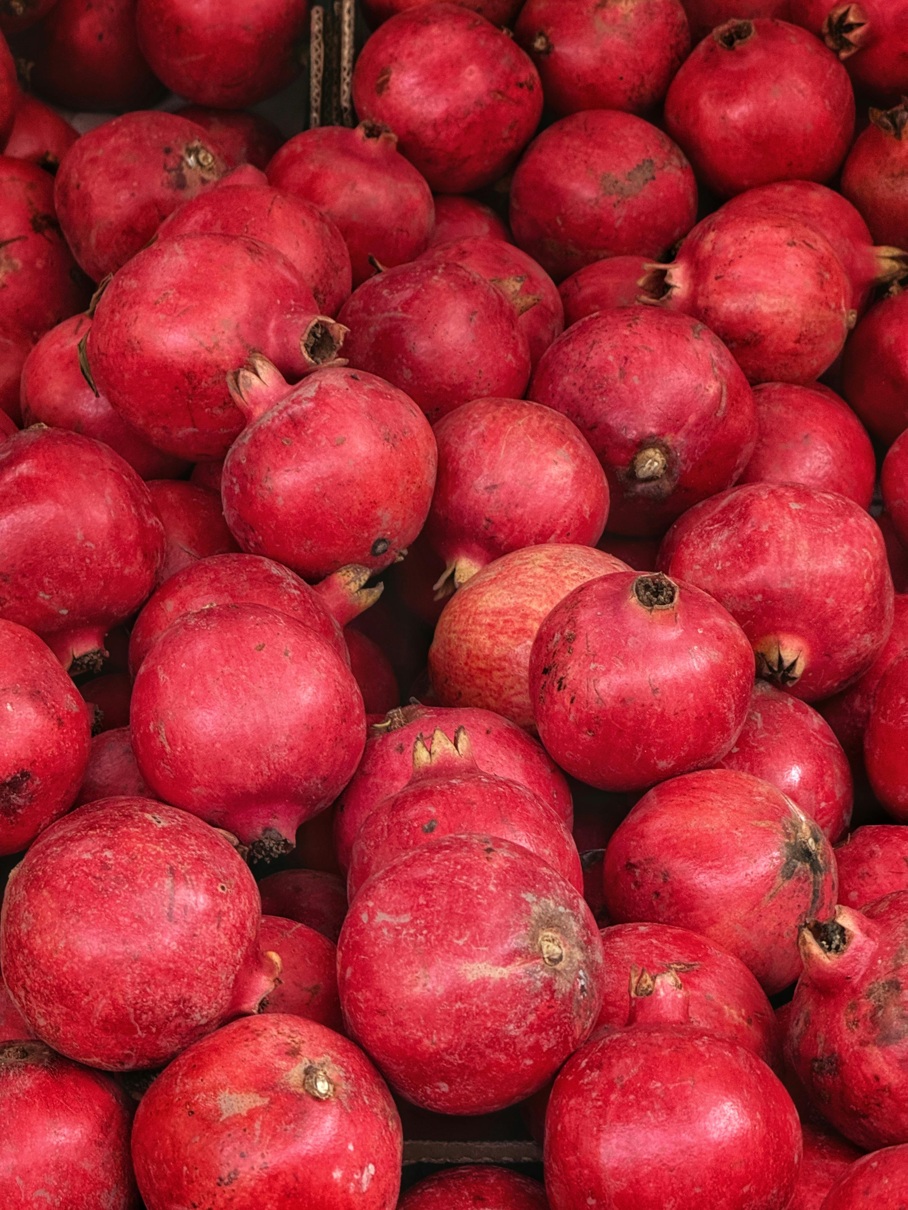 A colorful display of fresh pomegranates showcasing vibrant red hues, perfect for food and health themes.