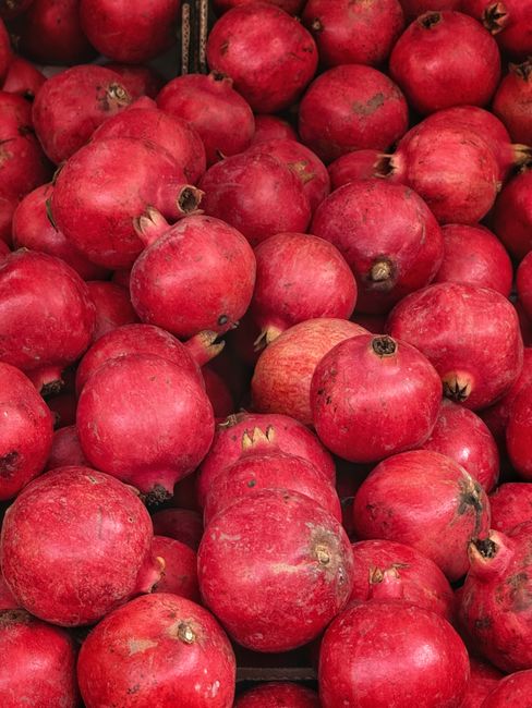 A colorful display of fresh pomegranates showcasing vibrant red hues, perfect for food and health themes.