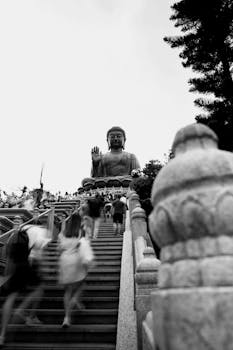Visitors climb stairs to the Tian Tan Buddha in Hong Kong, captured in black and white.