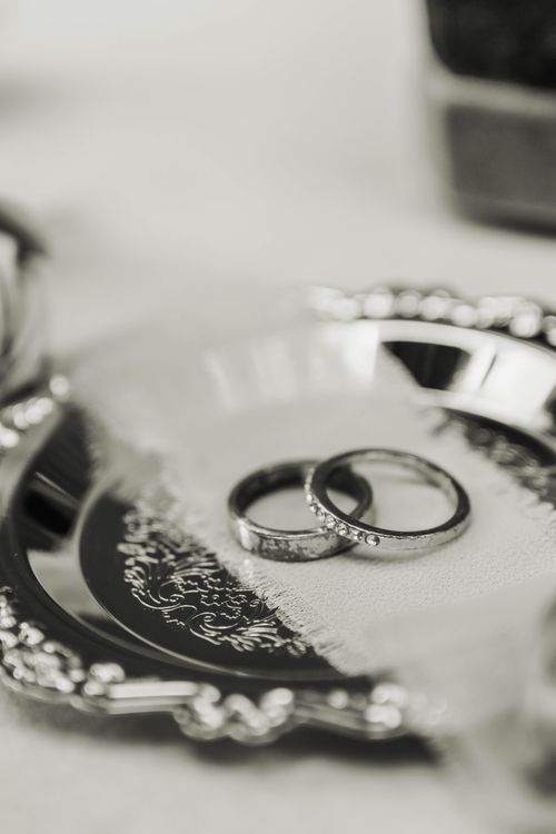 Free Close-up of wedding rings on a detailed silver tray, symbolizing love and commitment. Stock Photo