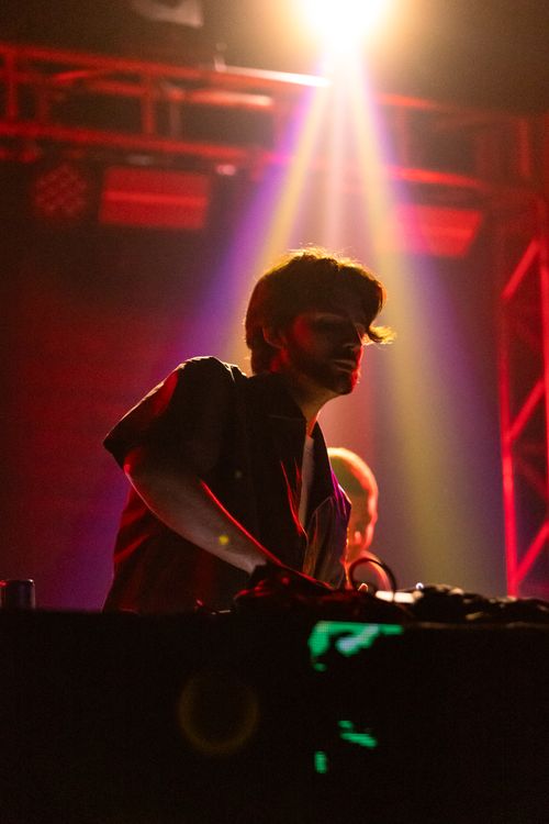 Free Energetic DJ set in a vibrant nightclub with colorful lighting and dynamic atmosphere. Stock Photo