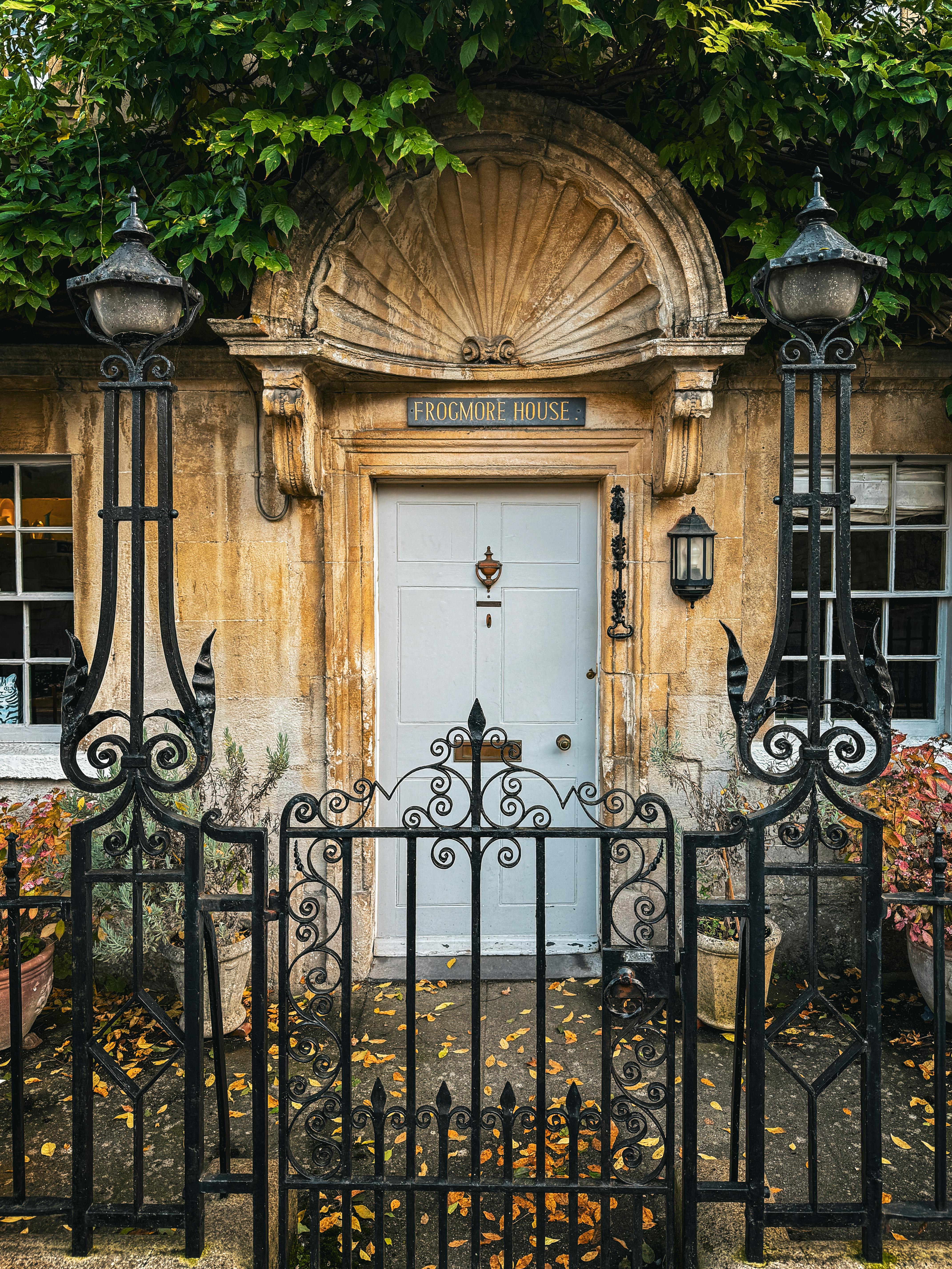 Front view of Frogmore House with intricate iron gate and autumnal leaves in Box, England.