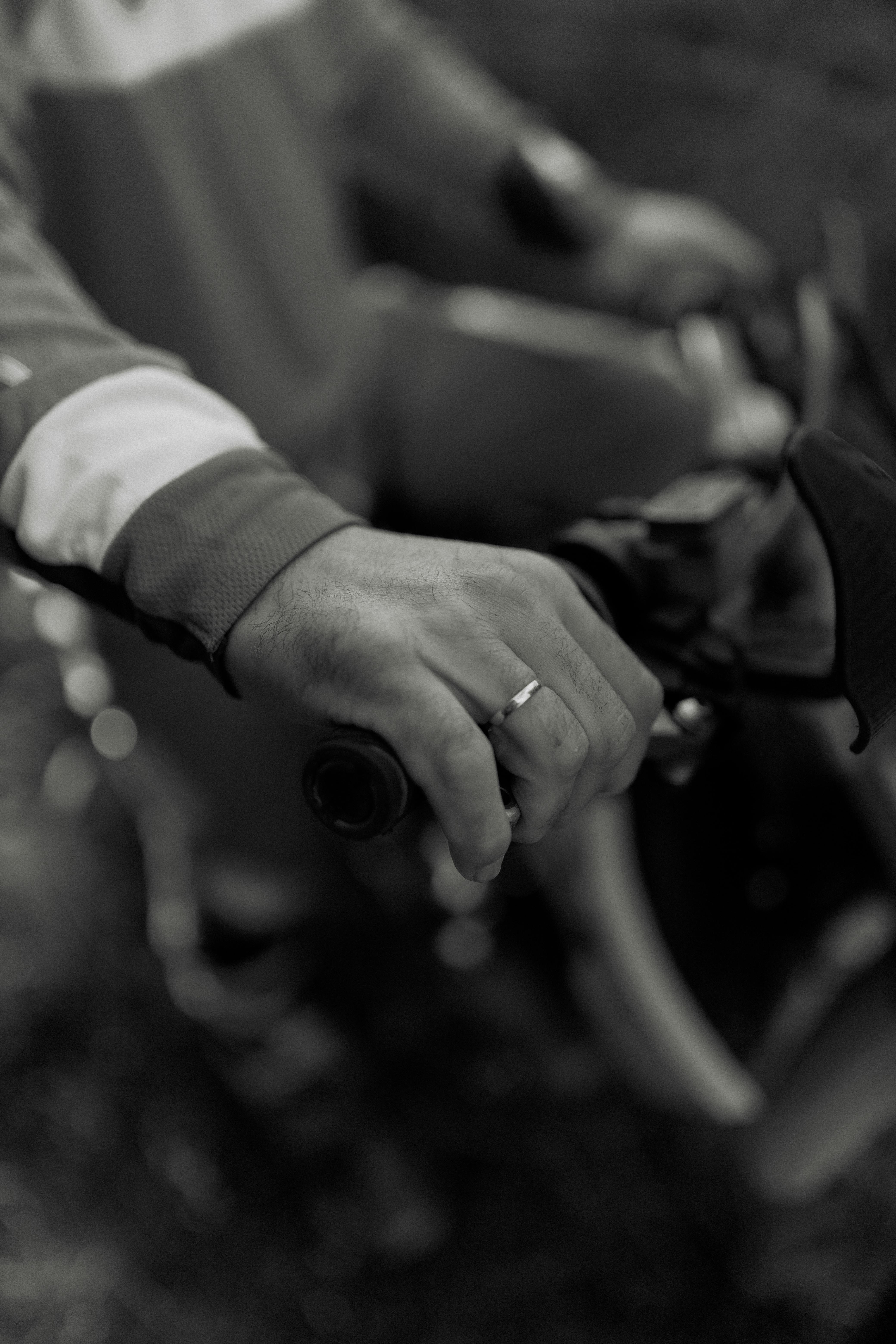 Kostenlos Künstlerisches Schwarzweißbild einer Person, die einen Fahrradlenker umklammert. Fängt Bewegung und Textur ein. Stock-Foto