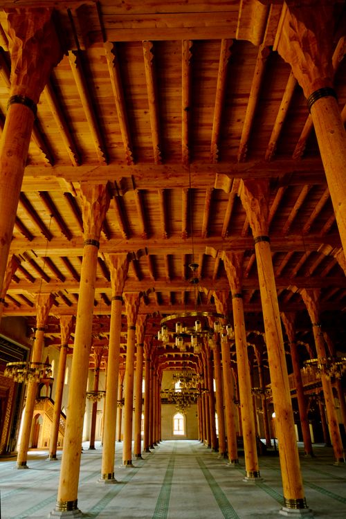 Free Intricate wooden pillars and ceiling inside an ornate mosque interior. Stock Photo