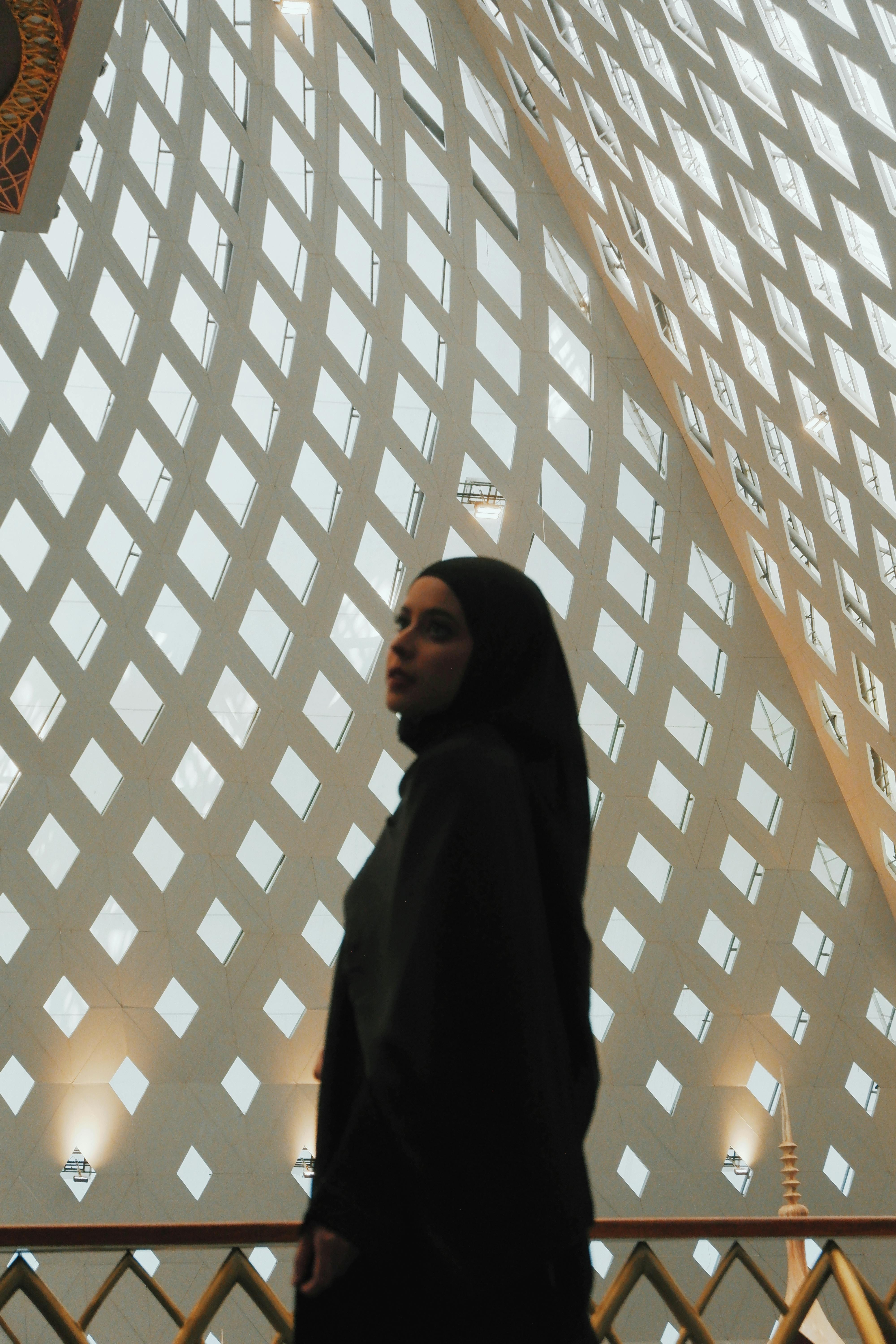 Bezpłatne Sylwetka kobiety wewnątrz meczetu prezentującego misterną architekturę islamską w Jawa Barat w Indonezji. Zdjęcie z galerii