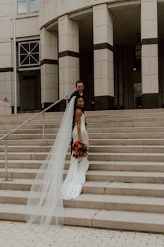 A newlywed couple poses stylishly on the architectural steps of a building in Orlando, Florida.