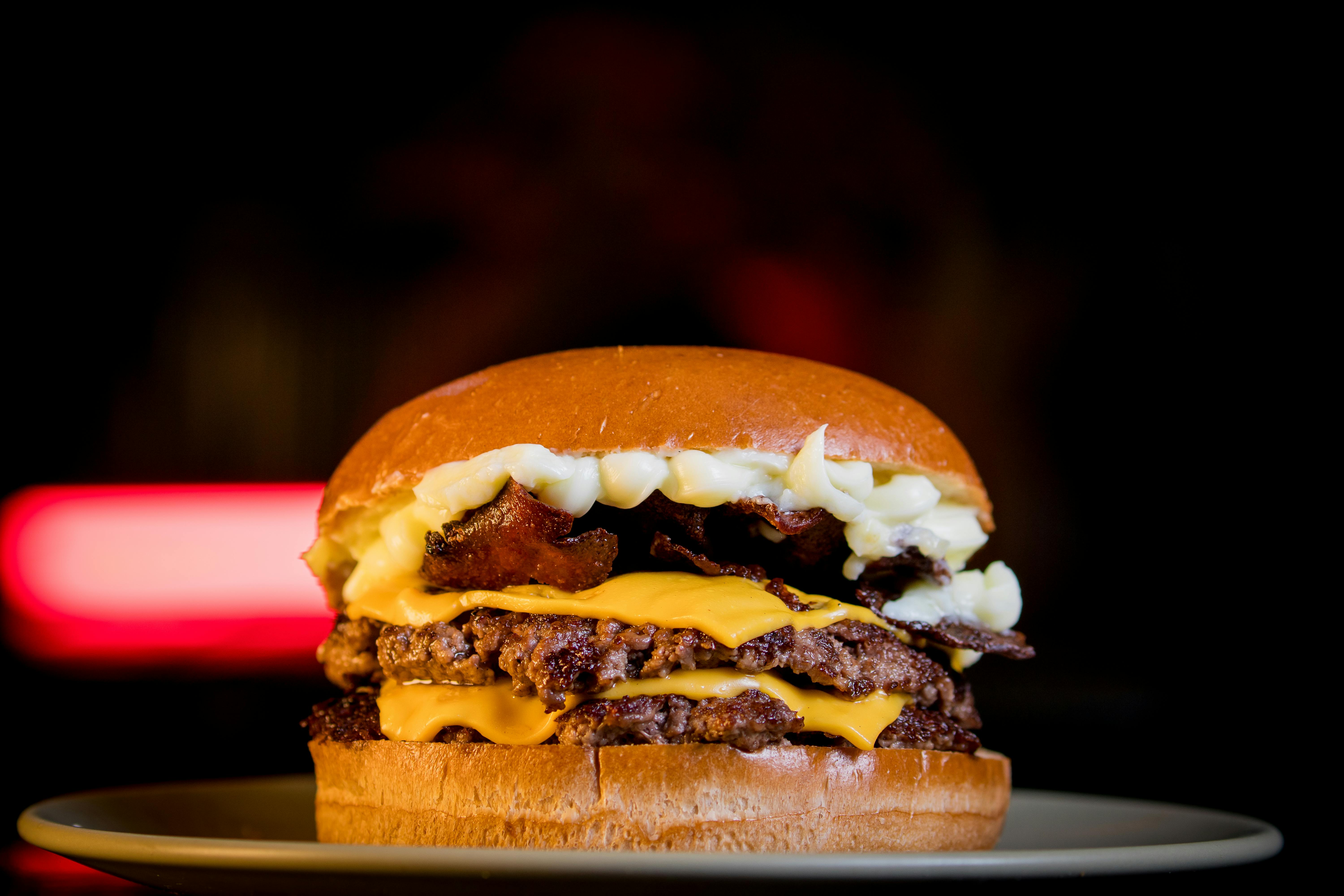 Mouthwatering double cheeseburger with crispy bacon and creamy cheese on a plate.