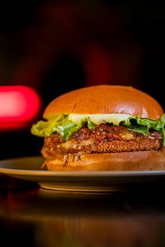A close-up of a delicious gourmet burger with fresh lettuce and cheese on a bun.