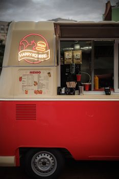Vibrant retro food truck featuring a neon 'Happy Squirrel' sign and menu board.
