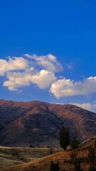 Beautiful mountain scenery with vivid skies and fluffy clouds, ideal for nature and travel themes.