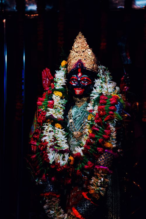 Free Vivid statue of Goddess Kali adorned with colorful floral garlands and intricate jewelry. Stock Photo