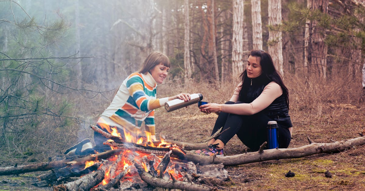 Two Women Sitting in Front of Burning Firewood
