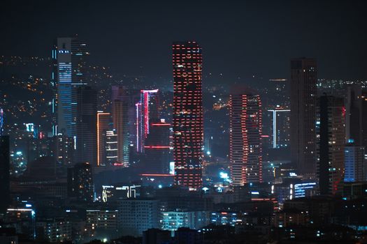 Captivating view of İzmir's illuminated skyscrapers at night, showcasing modern architecture.