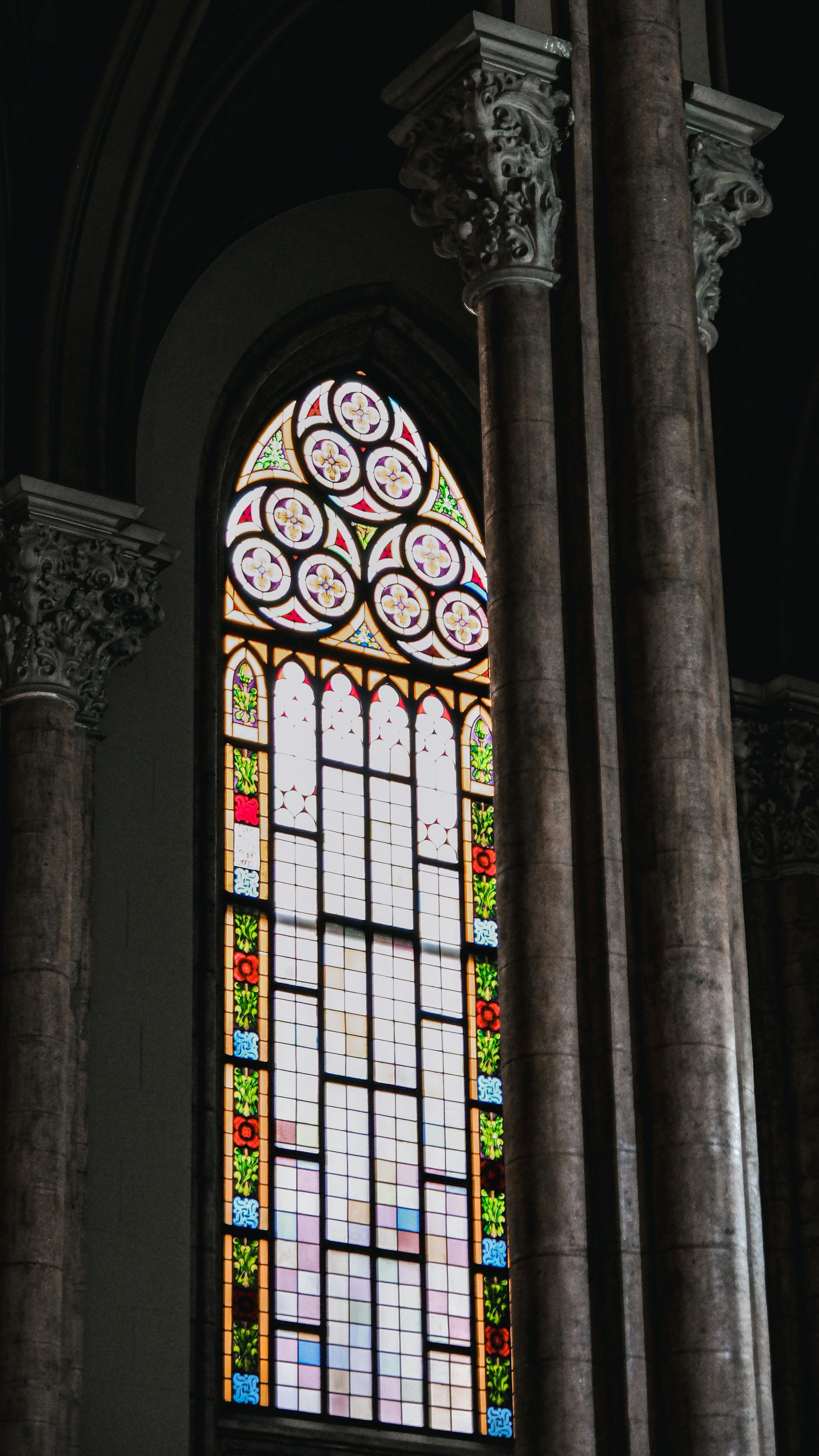 A beautiful Gothic stained glass window in a cathedral with intricate designs.