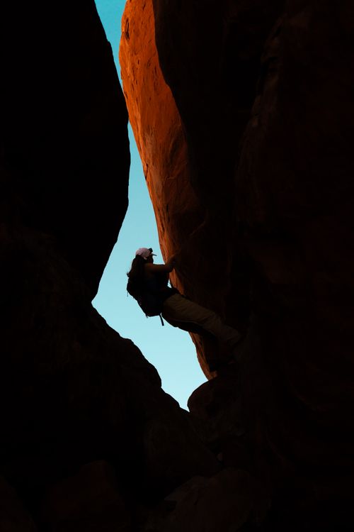 Free Silhouette of a woman climbing a slot canyon in Utah during dusk. Adventure awaits. Stock Photo