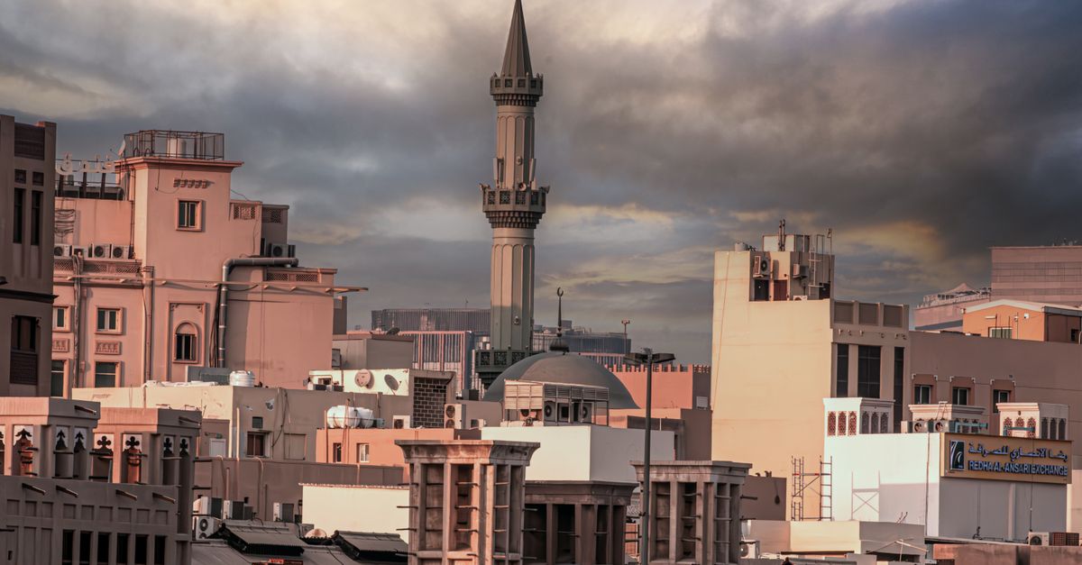 Dramatic skyline of Dubai with traditional and modern architecture at twilight.