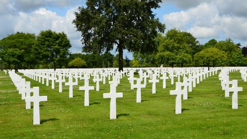 Free Peaceful scenery of a military cemetery in Normandie with white crosses and green landscape. Stock Photo