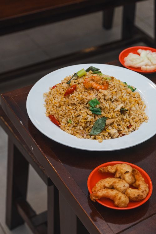 Free Delicious Indonesian fried rice with seafood, served with a side dish, capturing authentic Asian cuisine. Stock Photo