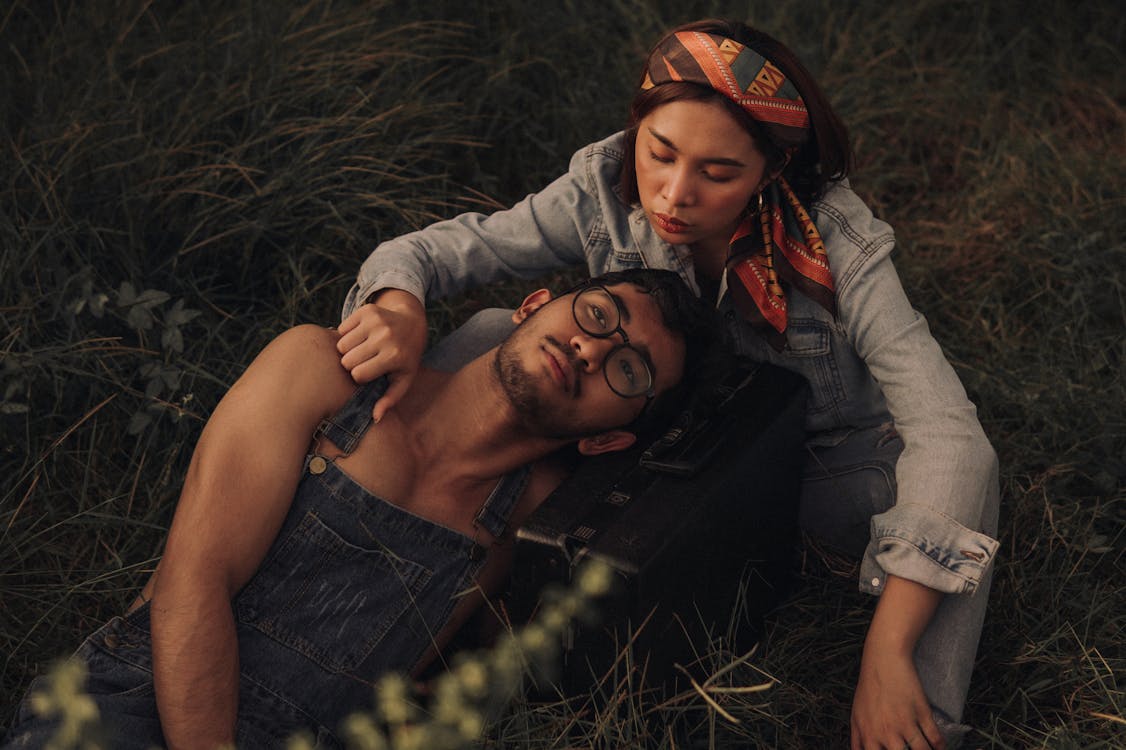 Couple Relaxing On Grassland · Free Stock Photo