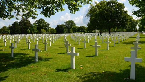 Free Peaceful cemetery landscape with rows of white crosses in Normandy, France, under a sunny sky. Stock Photo