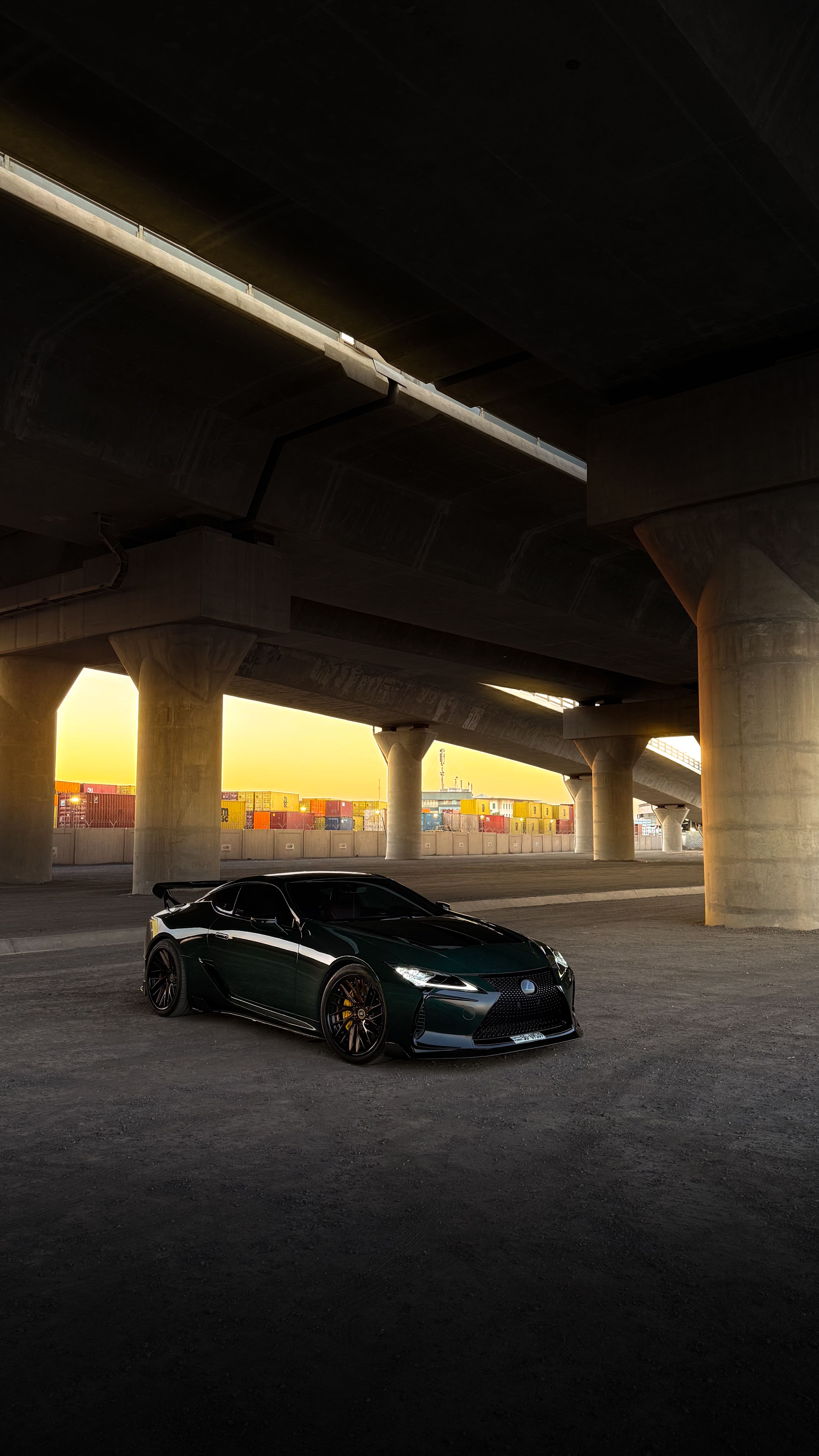 photorealistic silver luxury sports car side profile at night beneath a concrete overpass with soft atmospheric fog and reflective pavement, cinematic wide composition, no logos