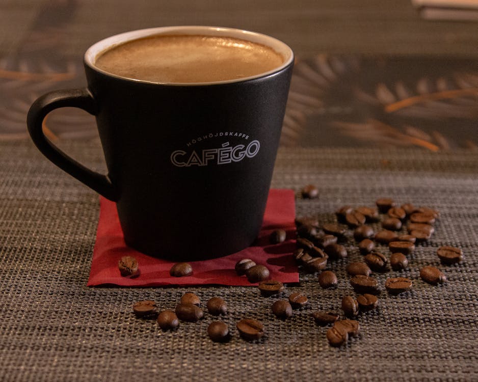 Free A Close-Up Shot of a Cup of Coffee and Coffee Beans Stock Photo