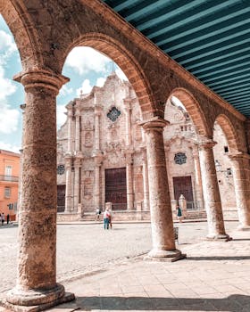 Stunning view of Plaza de la Catedral with historic arches and stone columns in Havana, Cuba.